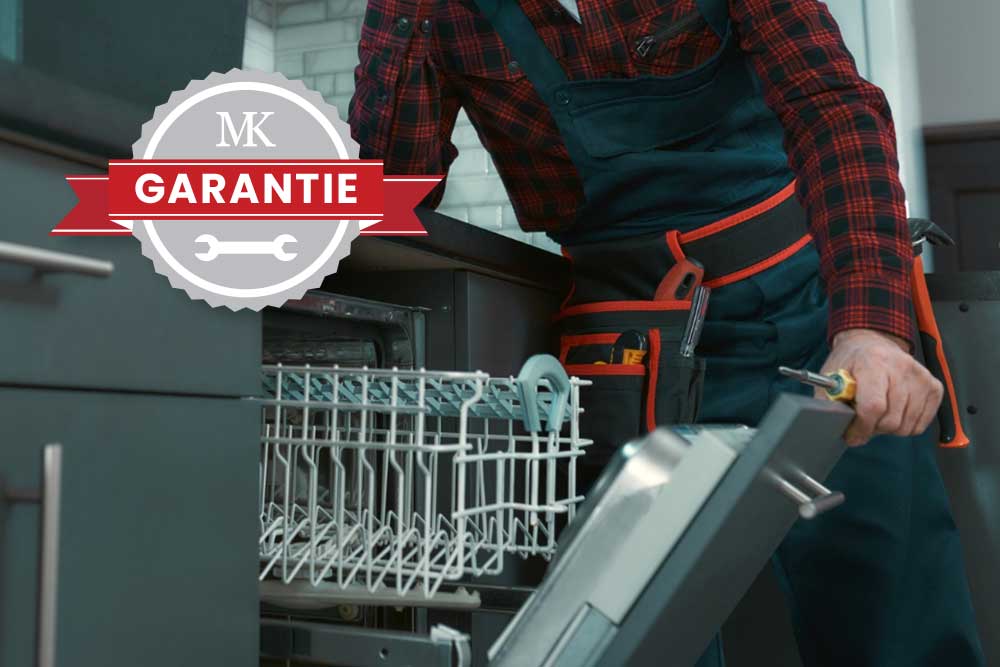 Techniker öffnet mit einer Hand, in der er auch einen Schraubendreher hält, einen Einbaugeschirrspüler.