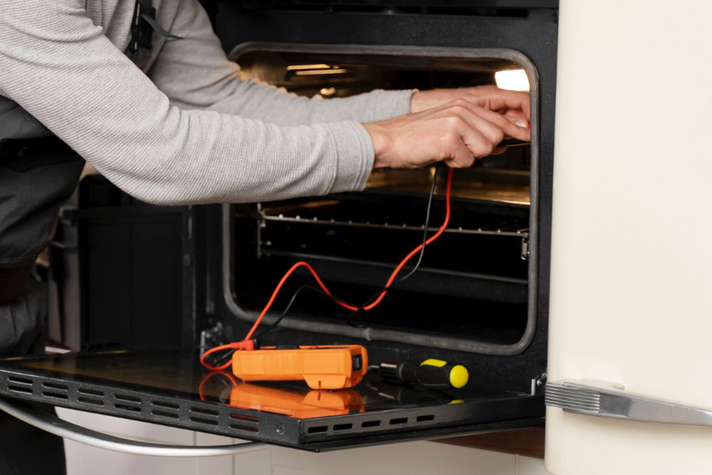 Zwei Arme und Hände, die ein Elektromessgerät in einen Backofen halten