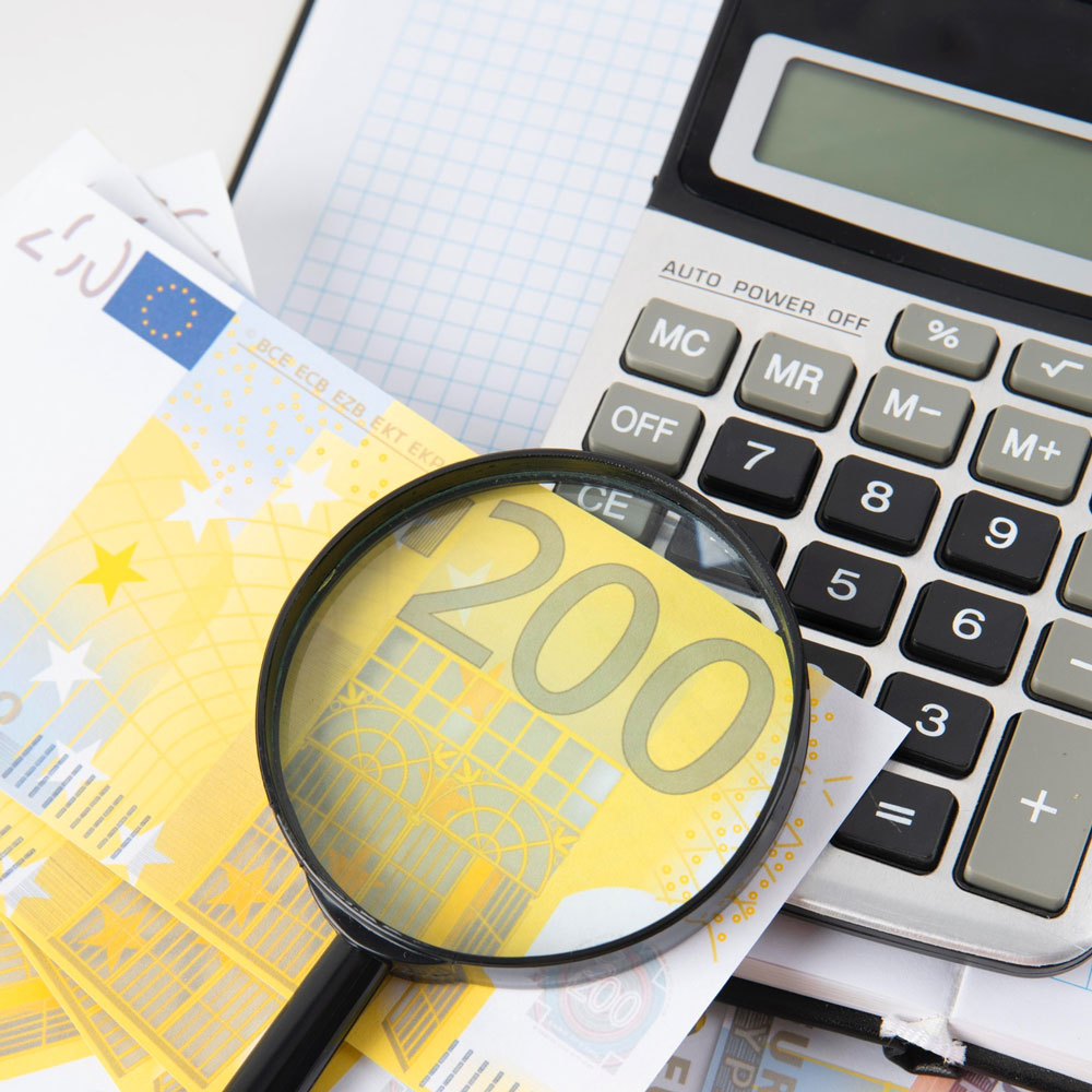 200 Euroschien, eine Lupe und ein Taschenrechner